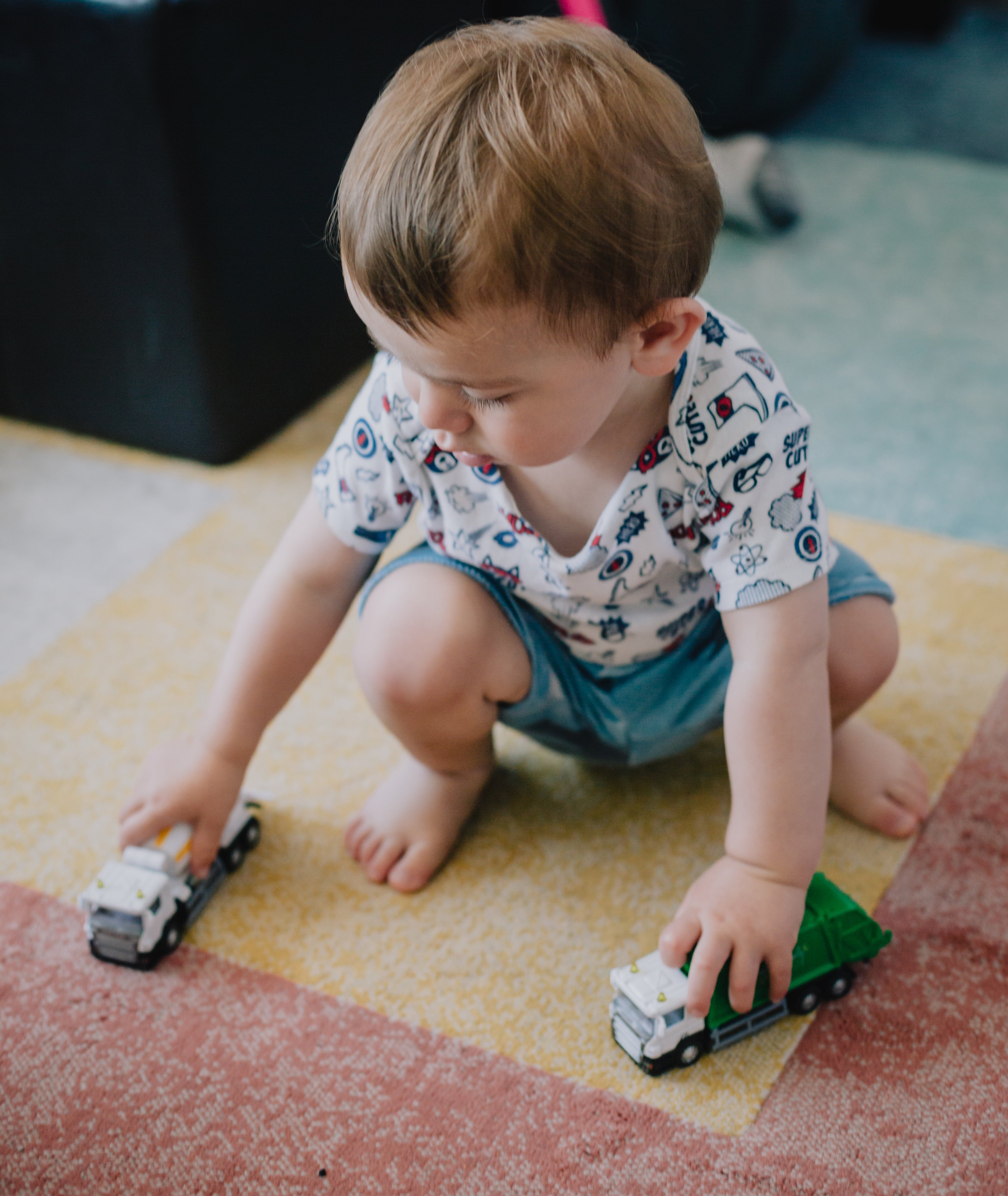 files/small-child-squats-and-plays-with-toy-trucks.jpg